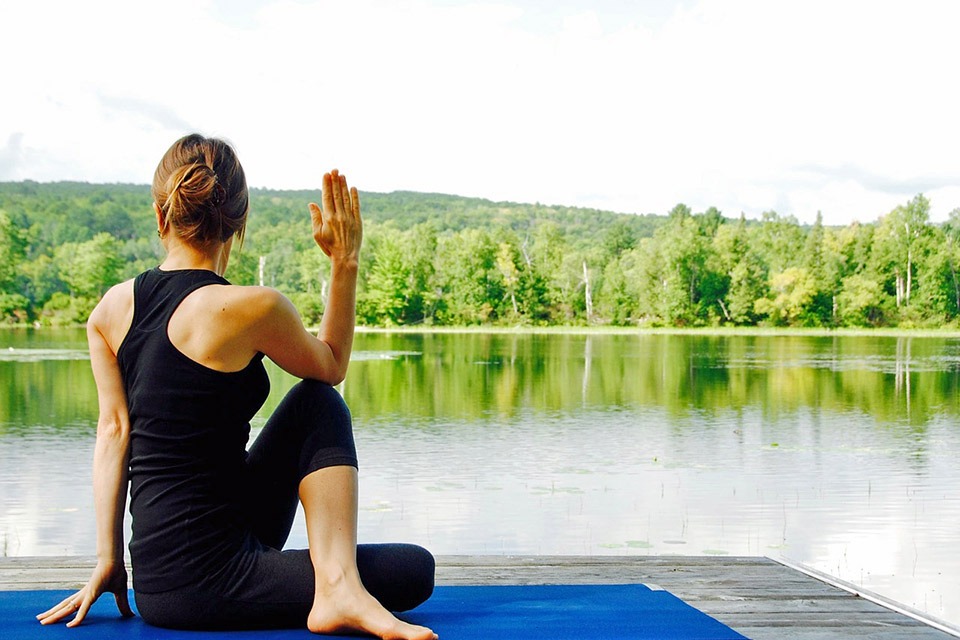 Woman practicing Yoga by the lake