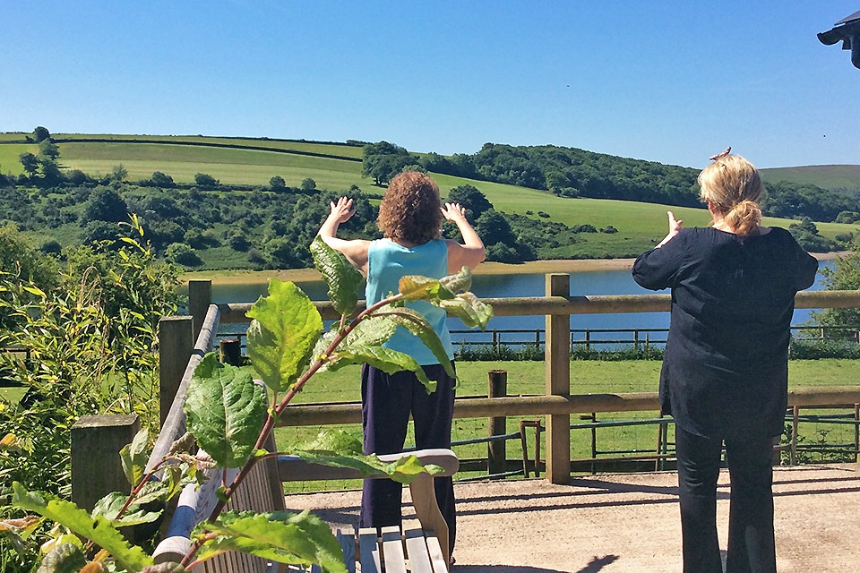 Two women performing gentle movements by Wimbleball Lake