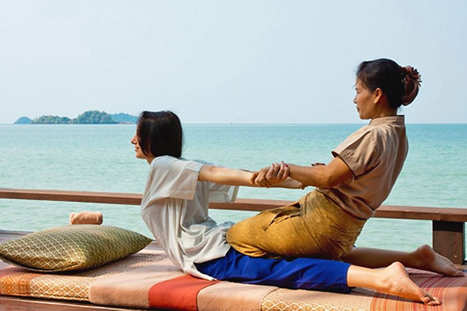 Woman and practitioner performing Thai Yoga Massage