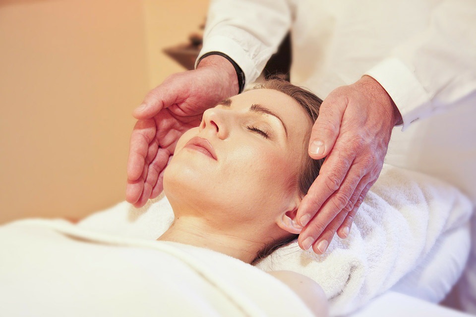 Woman relaxing while receiving Craniosacral Therapy